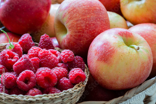 fresh raspberries and apples in a basket