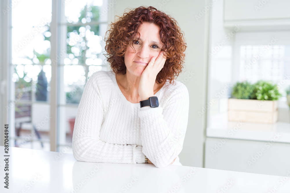 Beautiful senior woman wearing white sweater at home thinking looking tired and bored with depression problems with crossed arms. Beautiful senior woman wearing white sweater at home thinking looking tired and bored with depression problems with crossed arms.