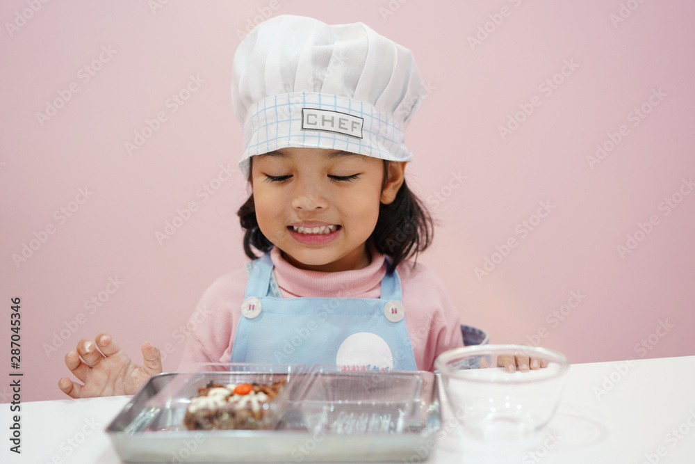 Happy Asian kid is preparing the dough, bake cookies in the Kitchen. bakery concept. Happy Asian kid is preparing the dough, bake cookies in the Kitchen. bakery concept.