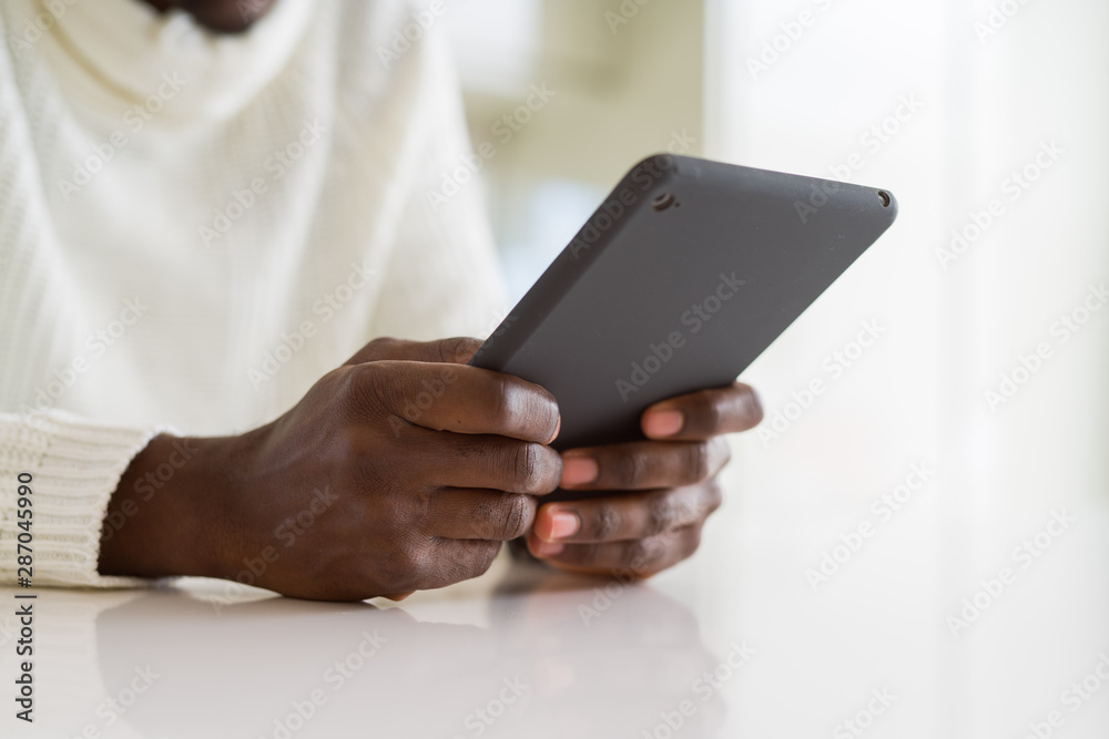 Close up of african business man using touchpad tablet, working sitting on a desk