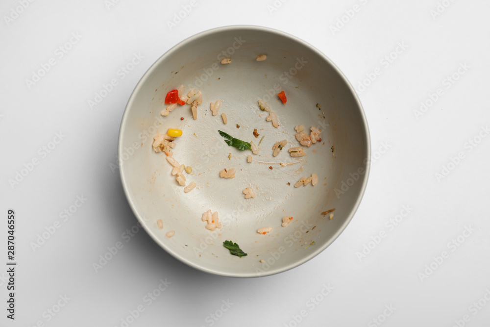 Dirty bowl with food leftovers on white background, top view Dirty bowl with food leftovers on white background, top view