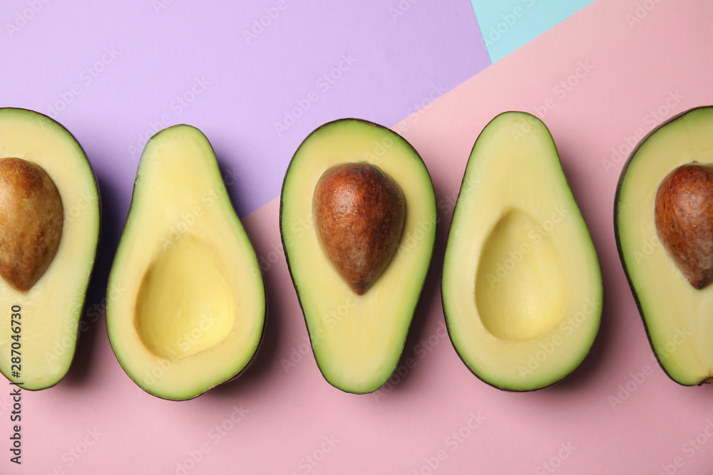 Cut fresh ripe avocados on color background, flat lay Cut fresh ripe avocados on color background, flat lay