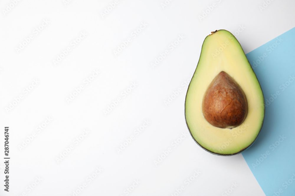 Cut fresh ripe avocado on color background, top view with space for text