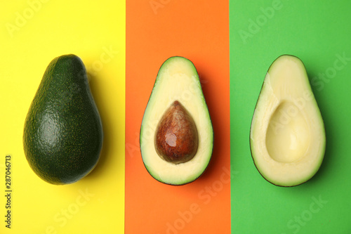 Cut and whole fresh ripe avocados on color background, flat lay
