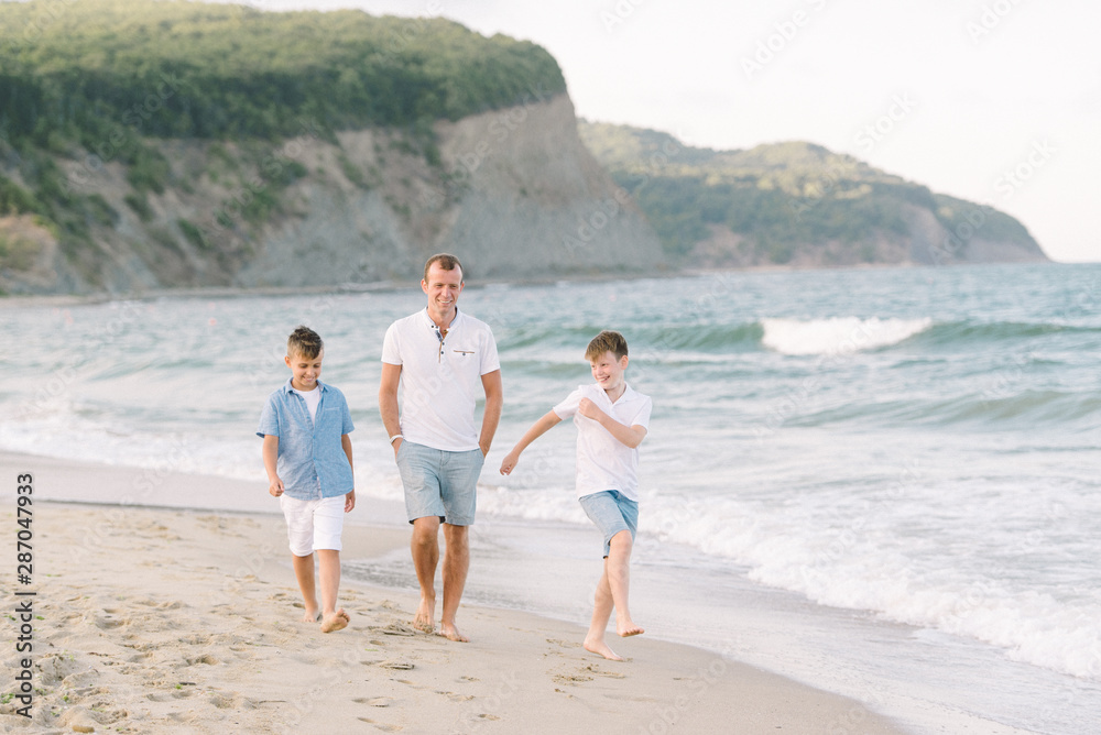 the father with sons on the beach