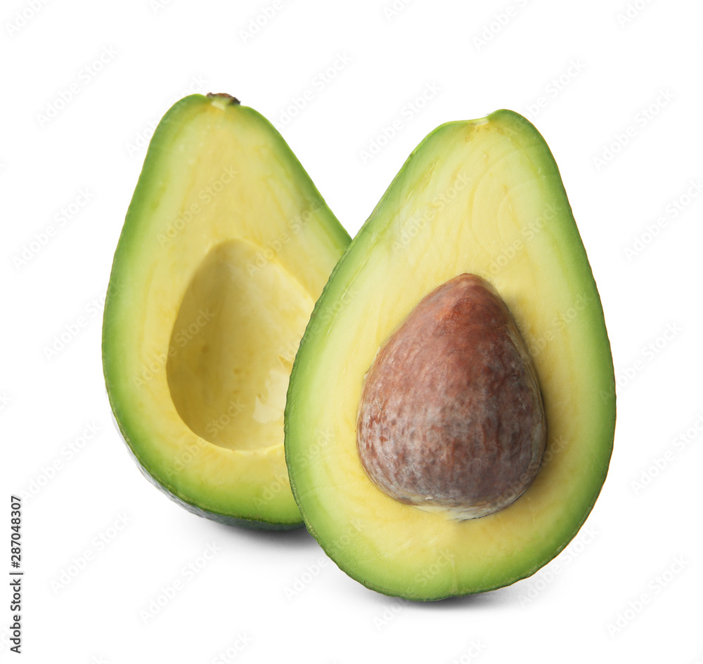 Halves of ripe avocado with pit on white background