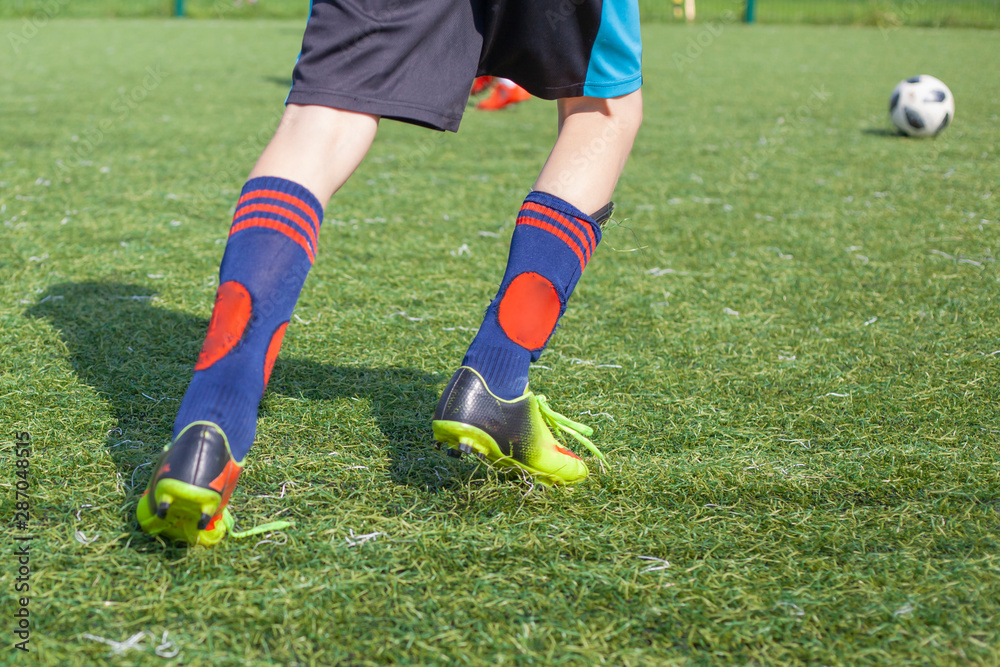 Soccer player in training. The feet of a football player. Ball game on the soccer field. Sports activities. Soccer player in training. The feet of a football player. Ball game on the soccer field. Sports activities.