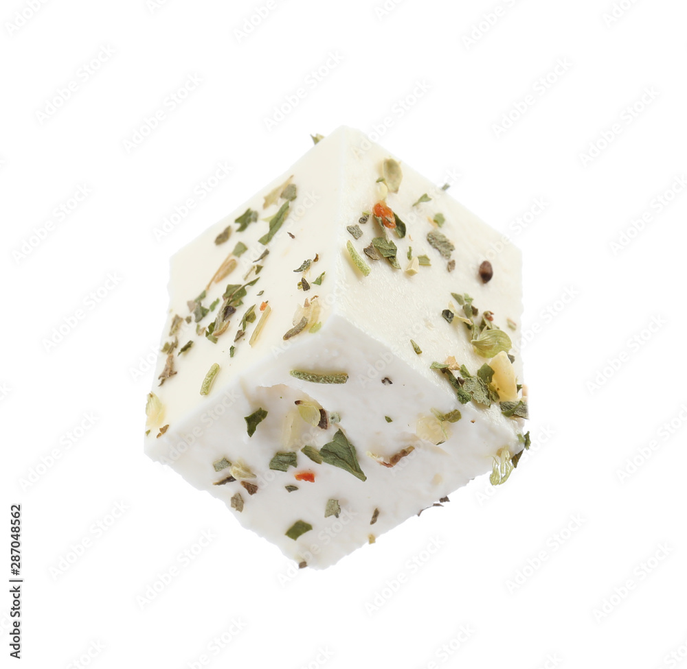 Piece of delicious feta cheese with seasoning on white background