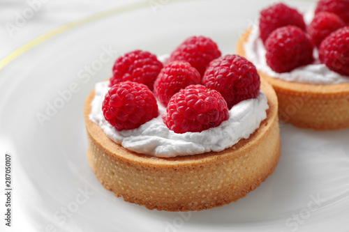 Plate with raspberry tarts, closeup. Delicious pastries