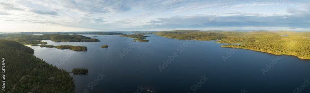 Aerial shot above forest while sunset. Summer sunset by the lake, color sky. Pine Forest during Sunset