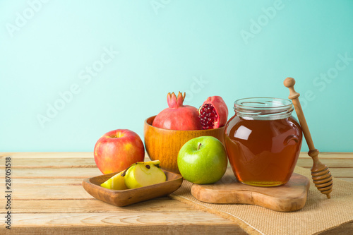 Fototapeta Naklejka Na Ścianę i Meble -  Jewish holiday Rosh Hashana background with honey, apple and pomegranate on wooden table