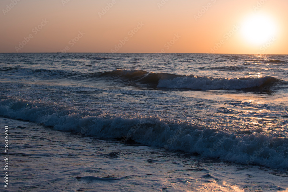 Sunset or dawn on the sea, waves and the sun.