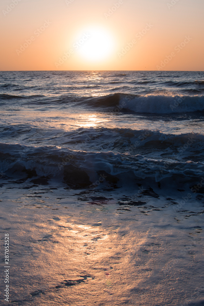 Sunset or dawn on the sea, waves and the sun.