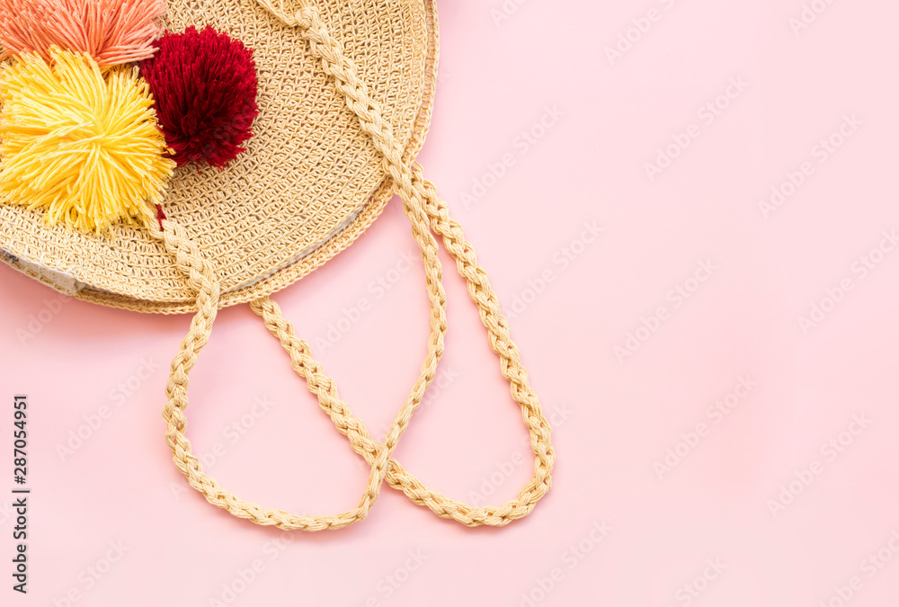 Fototapeta premium Modern stylish round straw bag on pink background, top view