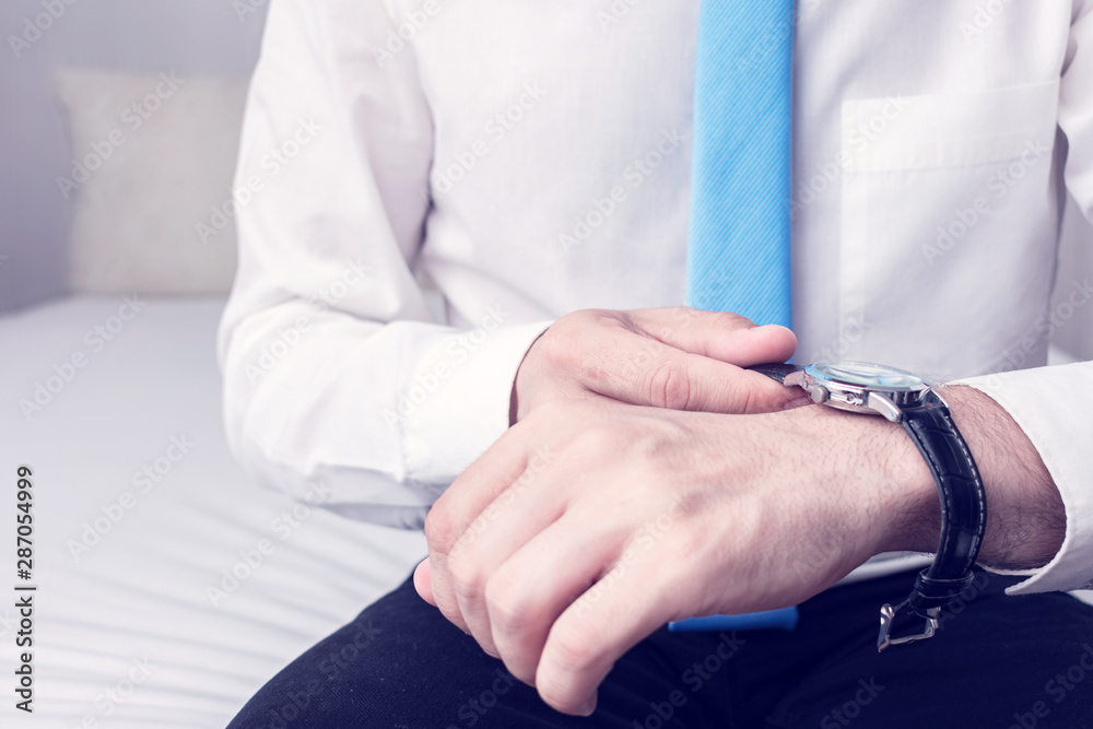 Office worker dressing up a shirt, the Manager is going to work, man's hands with clock, cropped image, closeup Office worker dressing up a shirt, the Manager is going to work, man's hands with clock, cropped image, closeup