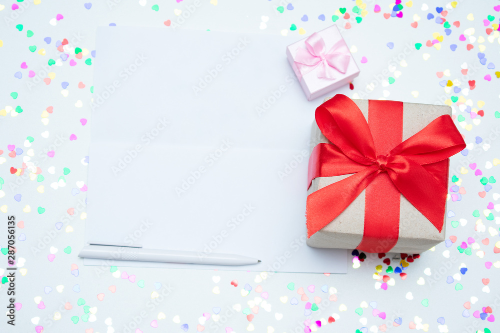 White desk with scattered tinsel, two gift box, letter, close up, copy space, text, top view
