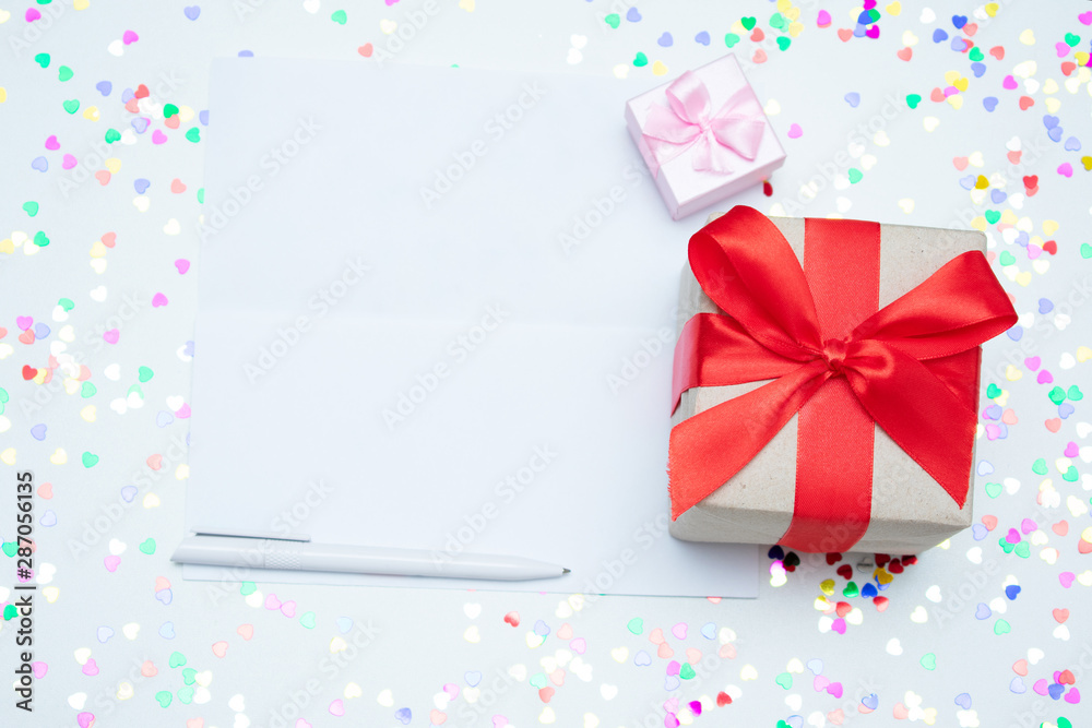 White desk with scattered tinsel, two gift box, letter, close up, copy space, text, top view White desk with scattered tinsel, two gift box, letter, close up, copy space, text, top view