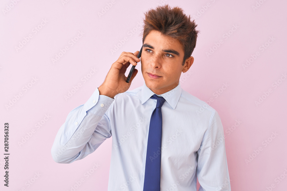 Young handsome businessman talking on the smartphone over isolated pink background with a confident expression on smart face thinking serious Young handsome businessman talking on the smartphone over isolated pink background with a confident expression on smart face thinking serious