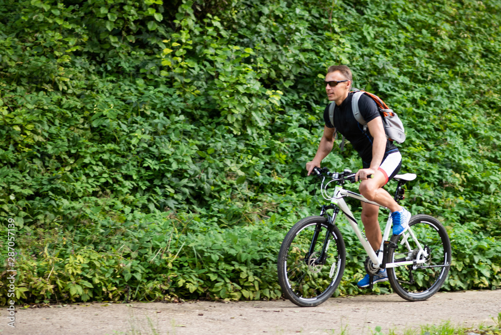 A man on a bicycle in the park. A man on a bicycle in the park.