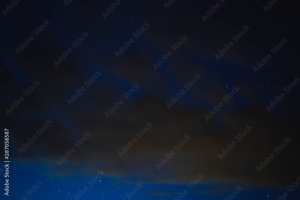 blue starry sky through gray clouds