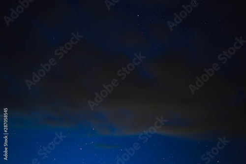 blue starry sky through gray clouds
