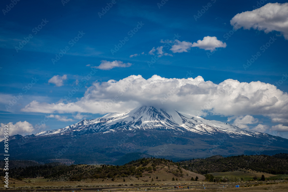 Deep blue skies and some low clouds cover the tip of Mt. Shasta