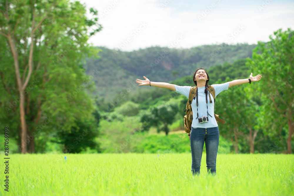 Portrait of traveler asian girl with backpack camera enjoy on green meadow at natural park ,Travel education lifestyle healthy environment concept Portrait of traveler asian girl with backpack camera enjoy on green meadow at natural park ,Travel education lifestyle healthy environment concept