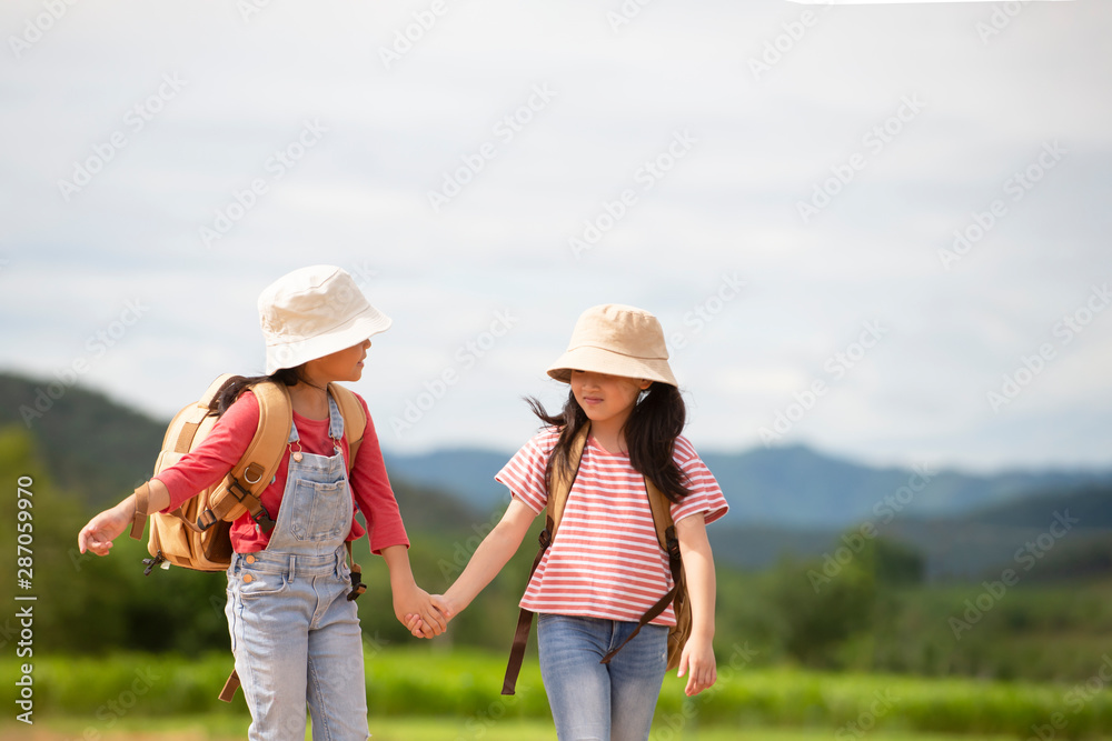 Relax  two asian  little girl with backpack walking in natural park , Travel education  lifestyle healthy concept
