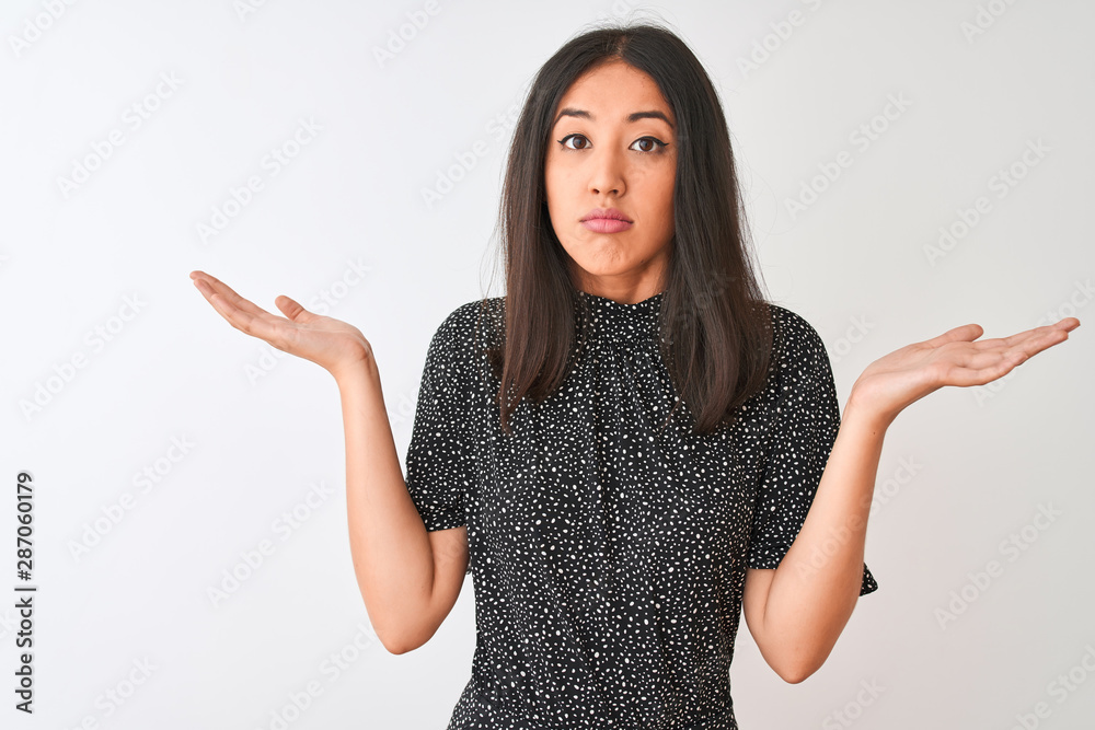 Young chinese woman wearing elegant t-shirt standing over isolated white background clueless and confused expression with arms and hands raised. Doubt concept. Young chinese woman wearing elegant t-shirt standing over isolated white background clueless and confused expression with arms and hands raised. Doubt concept.