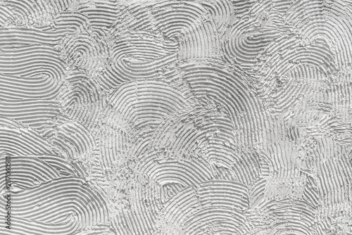Photo of white stucco in the form of a pattern of relief stripes with irregular semicircles