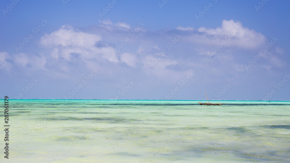 Wooden Fishing Boat in turquoise waters of Indian ocean,Zanzibar,Tanzania Wooden Fishing Boat in turquoise waters of Indian ocean,Zanzibar,Tanzania