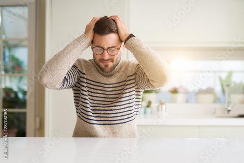 Fotografie Young handsome man wearing glasses at home suffering from headache desperate and stressed because pain and migraine