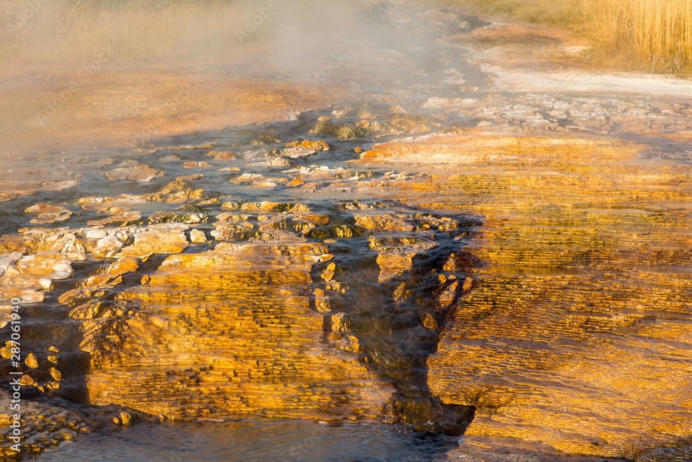 Fototapeta premium hot water flowing between the orange stones