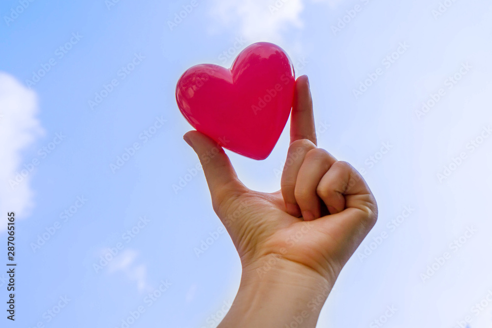 Fototapeta premium Hand holding heart with blue sky