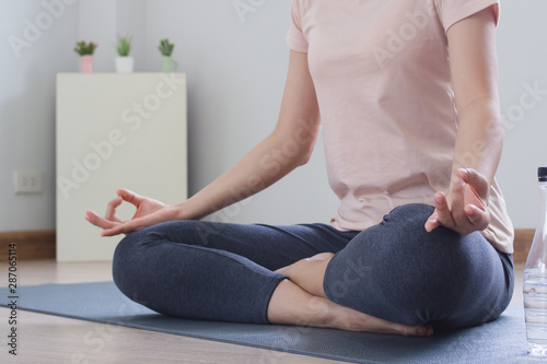 Fototapeta Naklejka Na Ścianę i Meble -  Yoga and meditation lifestyles. close up view of young beautiful woman practicing yoga namaste pose in the living room at home.