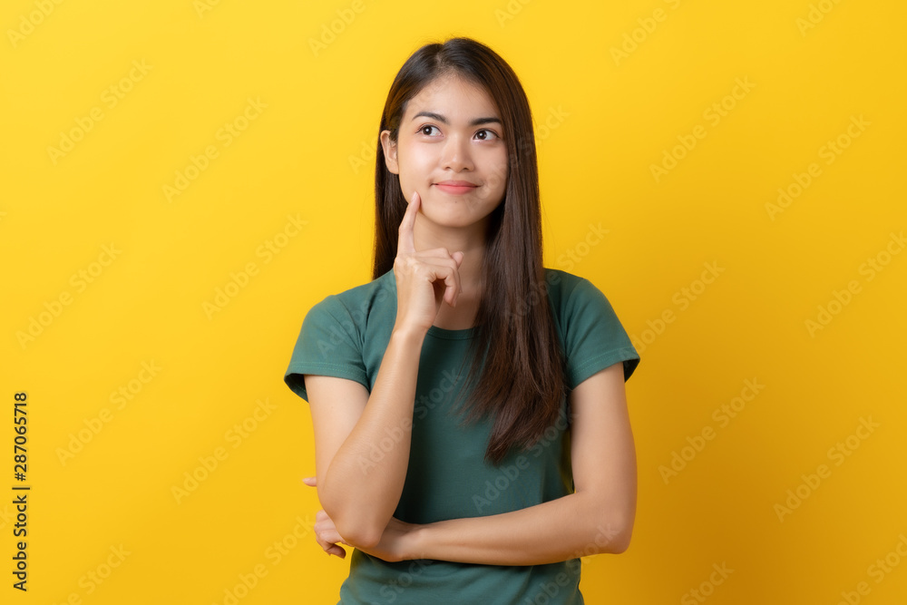 portrait of young woman thinking isolated on yellow background. portrait of young woman thinking isolated on yellow background.