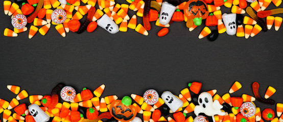 Halloween candy double border banner. Top view on a black background with copy space.