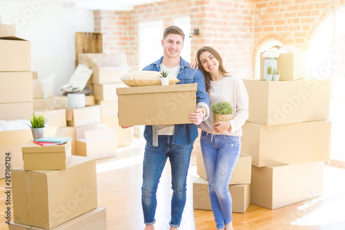 Beautiful young couple smiling in love holding cardboard boxes, happy for moving to a new home © Krakenimages.com