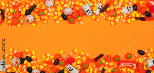 Halloween candy double border banner. Top view against an orange background with copy space.