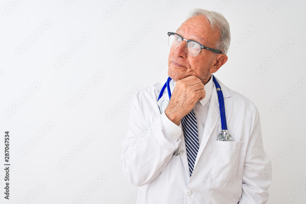 Senior grey-haired doctor man wearing stethoscope standing over isolated white background with hand on chin thinking about question, pensive expression. Smiling with thoughtful face. Doubt concept. Senior grey-haired doctor man wearing stethoscope standing over isolated white background with hand on chin thinking about question, pensive expression. Smiling with thoughtful face. Doubt concept.