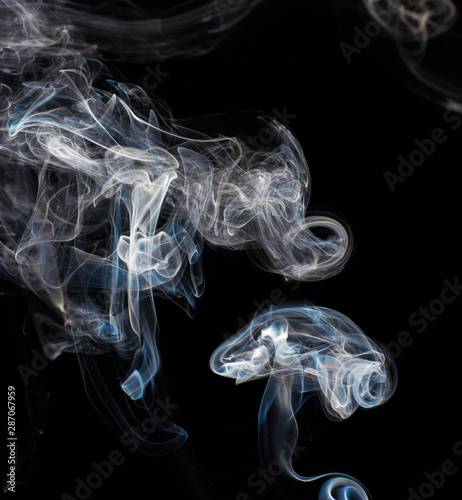 Abstract white smoke swirls on black background