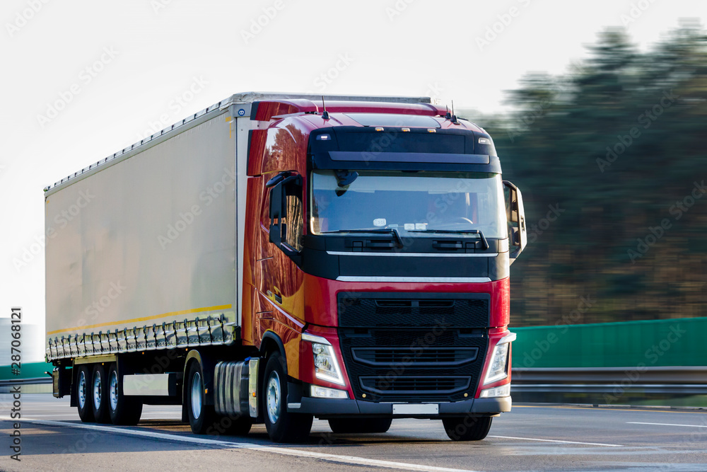 Red truck with white trailer with space for text, logos, images. The concept of cargo transportation, logistics. Red truck with white trailer with space for text, logos, images. The concept of cargo transportation, logistics.