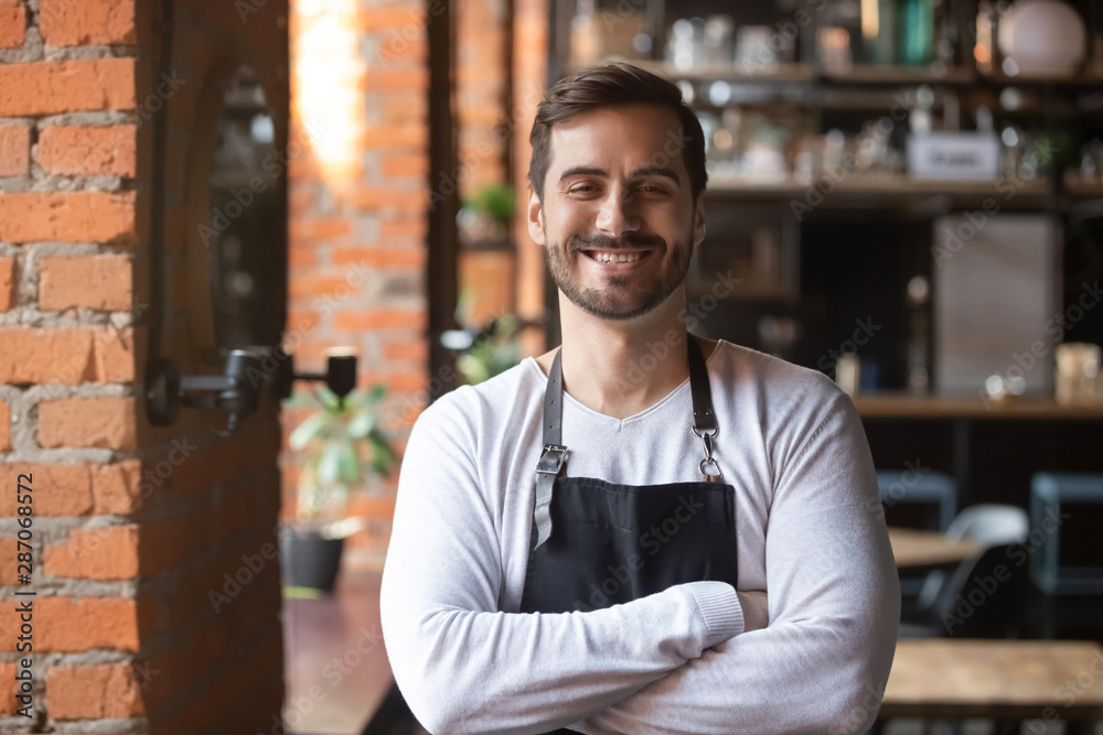 Obraz premium Happy confident young waiter entrepreneur looking at camera, portrait