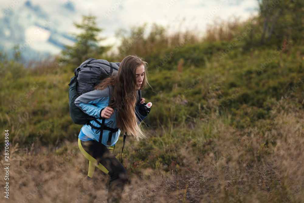 Woman hiker with backpack climbing the hill. Self improvement and life goals concept. Woman hiker with backpack climbing the hill. Self improvement and life goals concept.