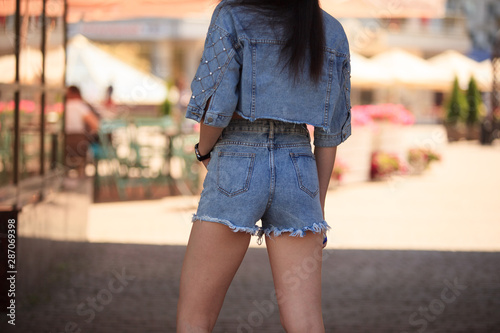 Sexy woman body in jean shorts. Girl with perfect body posing outdoor. Wearing jeans stylish shorts and jacket.