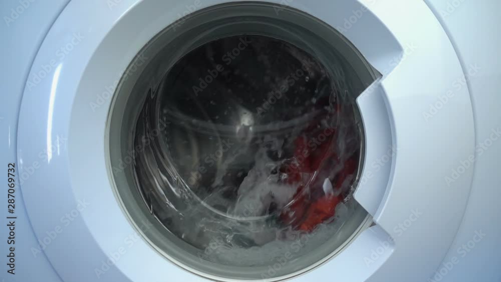 Close up view porthole of washing machine. Washing clothes process in slow motion. Close up view porthole of washing machine. Washing clothes process in slow motion.
