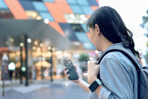 Attractive smart asian traveller woman use her smartphone to booking hotel in ecommerce website on omni channel platform. She can do every steps on only one mobile.