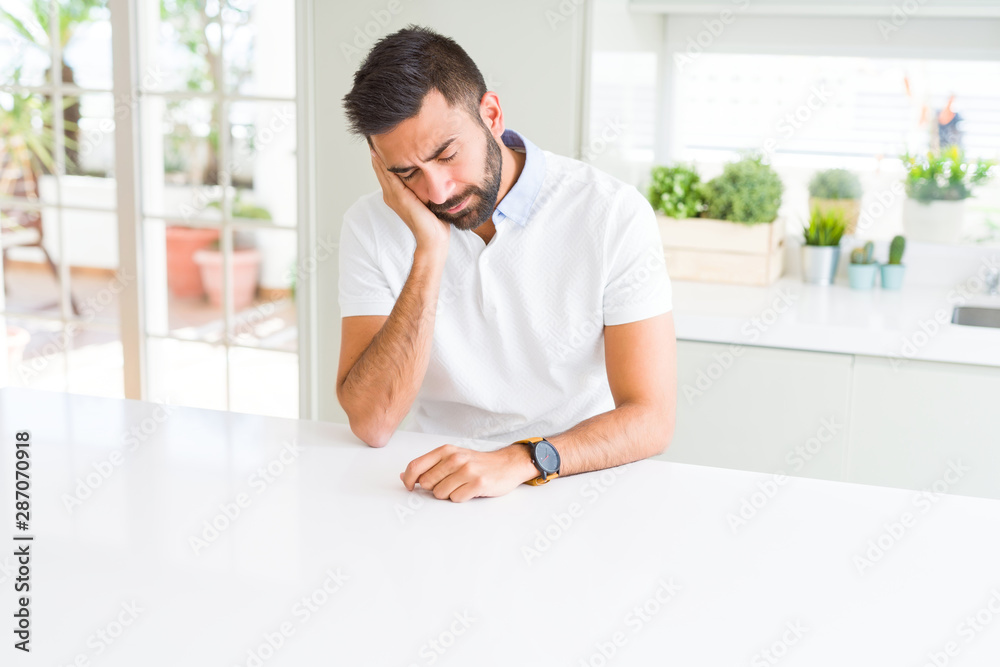 Handsome hispanic man casual white t-shirt at home thinking looking tired and bored with depression problems with crossed arms.