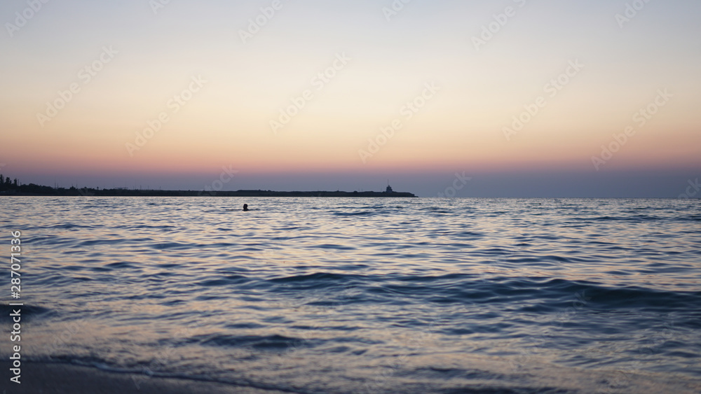 Sunset on the blue sea with breakwater into the dictance Sunset on the blue sea with breakwater into the dictance
