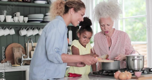 Three generations of family cooking a meal together photo